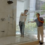 新業(yè)建設(shè)卓勝隆董事長（右）伸手測試三段式水流變化為肌膚帶來的觸感，親身體驗，精選出舒心的衛(wèi)浴設(shè)備。