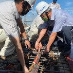 新業(yè)建設名譽董事長穆椿松先生（圖前排右一），於樓頂安裝「噴金漆鋼筋」即為上樑，古有云「上樑有如人之加冠」，不論在建築進度及民俗學上都極具意義。