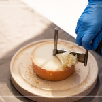 半硬質(zhì)家族的修道士(TETE DE MOINE)，呈小型鼓狀，外殼有點油膩、呈褐色，乳酪團(tuán)結(jié)實且濃郁，隨著熟成顏色會加深，以轉(zhuǎn)臺式乳酪削切器，削成花摺邊小花苞。