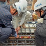 由新業(yè)建設名譽董事長穆椿松先生（圖左一）、卓勝隆董事長（圖右一）一同親手將主角「噴金漆鋼筋」綁紮、安置於屋頂中樑位置，代表著建築的穩(wěn)定與安詳。